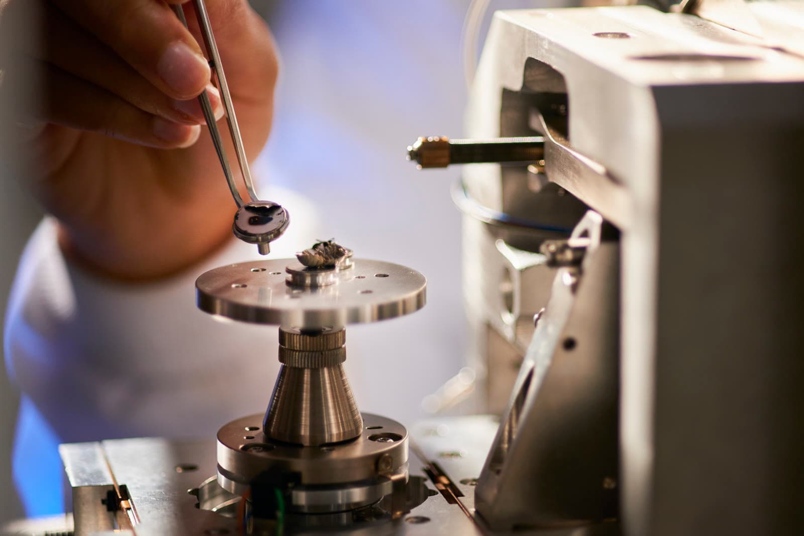 Pose d'une pièce usinée sur un équipement de mesure de précision à la pince, en laboratoire de métrologie